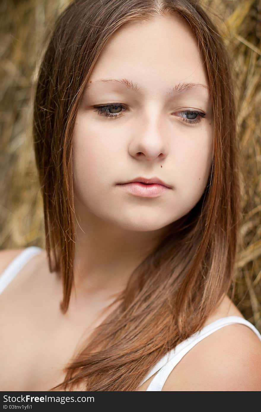 Pretty lady portrait with hay on background.