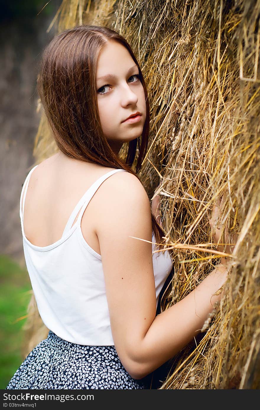 Young beauty portrait with hay on background.