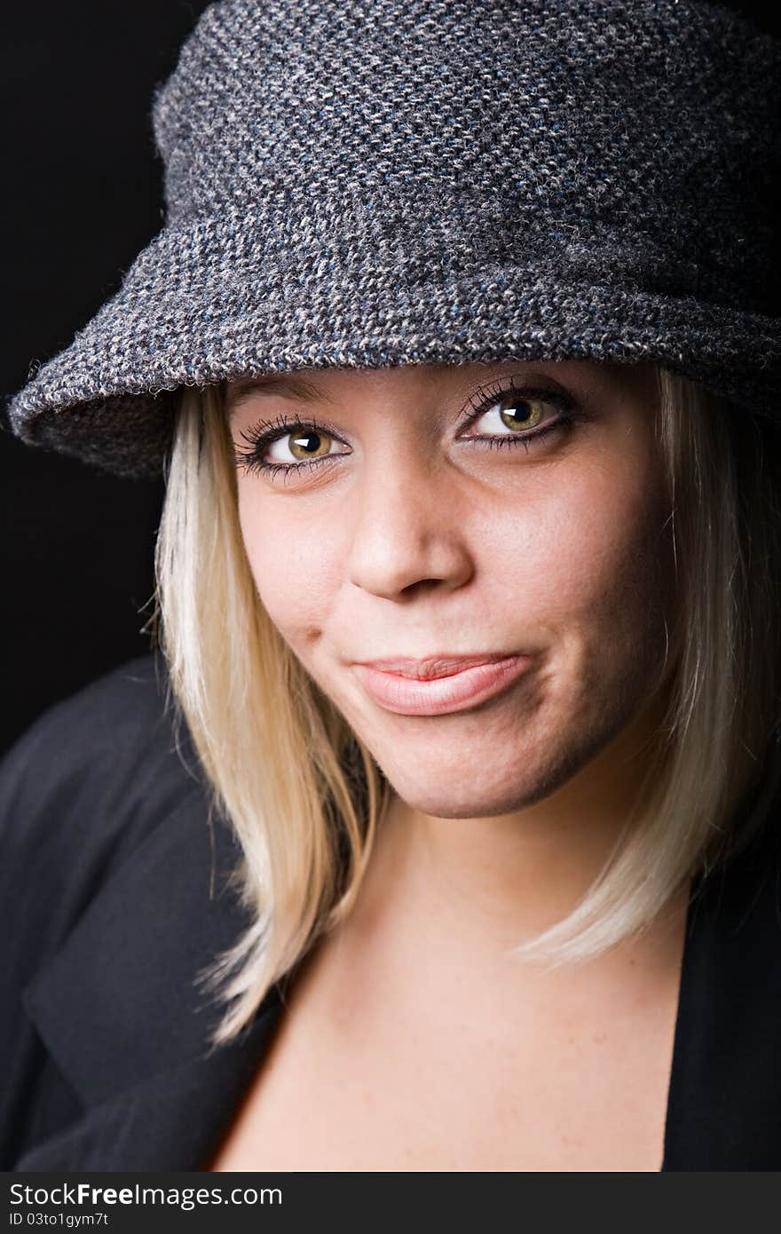 Beautiful young blonde girl wearing a tweed rain hat. Beautiful young blonde girl wearing a tweed rain hat