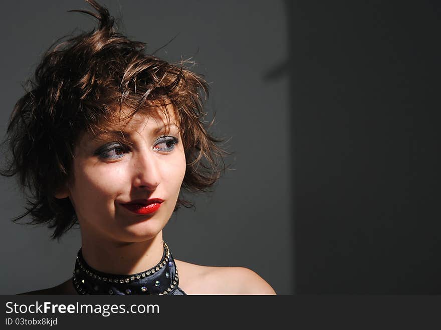 Portrait of girl with short long hair on a grey background