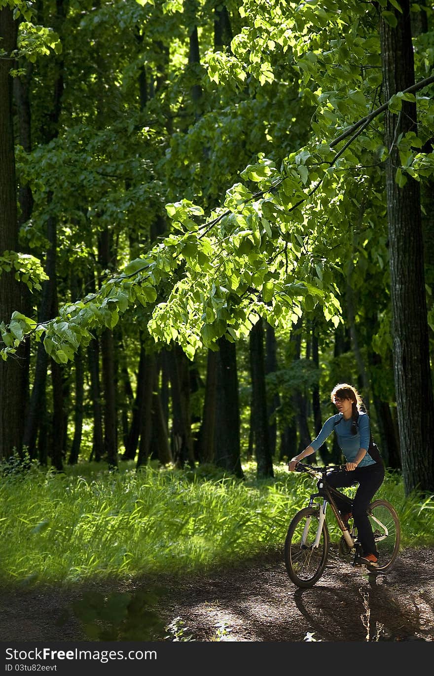 Young woman biking through the forest. Young woman biking through the forest