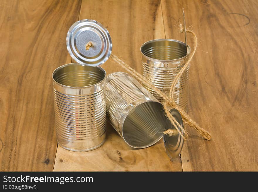 Three open cans on wooden table