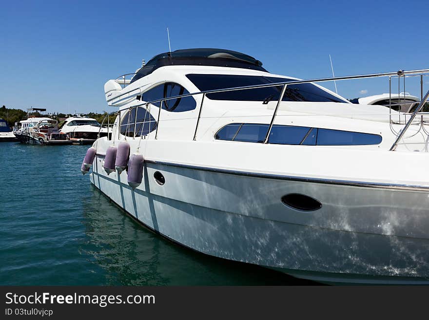 The white small yacht costs in a gulf at a pier. The white small yacht costs in a gulf at a pier