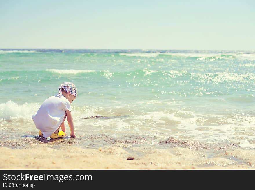 The child on the sea in a hat has a rest in the summer. The child on the sea in a hat has a rest in the summer