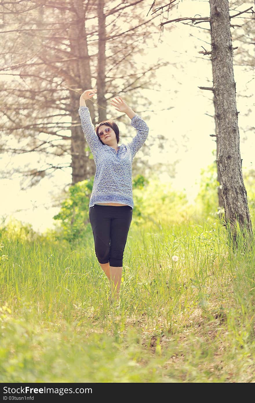 The girl dances in wood on a grass. The girl dances in wood on a grass