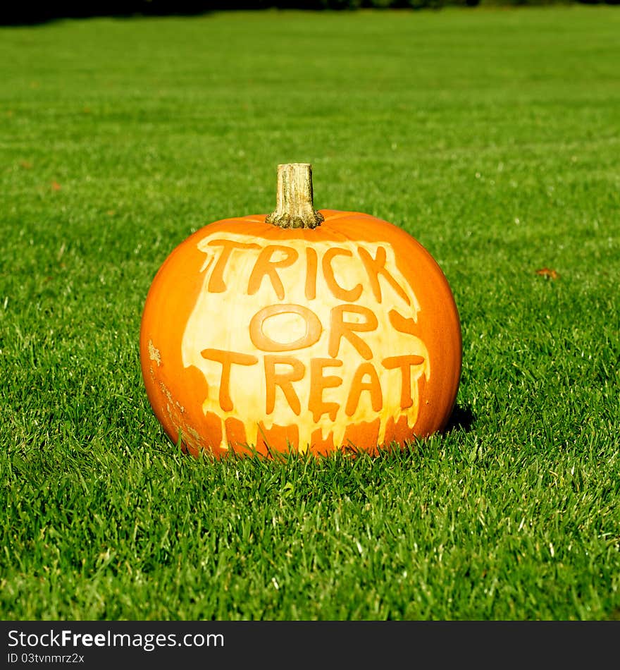 Picture of a pumpkin, with Trick Or Treat cut in the surface. Standing on a lawn. Picture of a pumpkin, with Trick Or Treat cut in the surface. Standing on a lawn