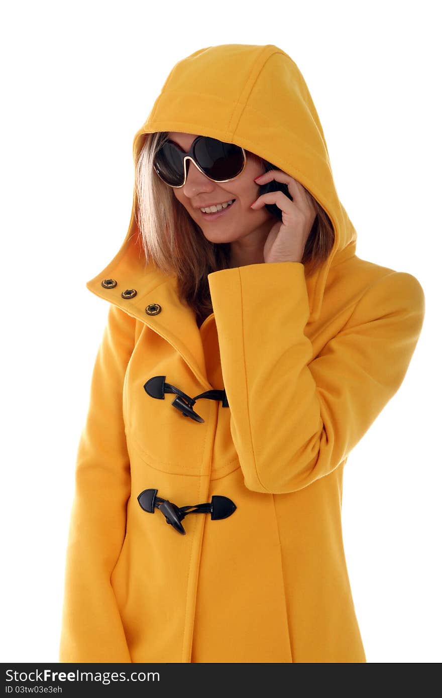 Stylish young lady in yellow hooded jacket on a call. Stylish young lady in yellow hooded jacket on a call
