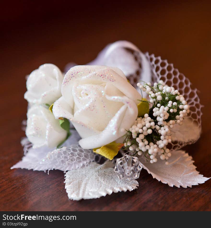 Satin wedding rose on a wooden table