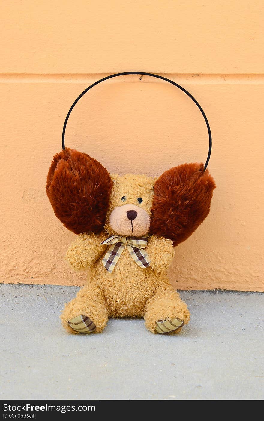 Teddy Bear with plaid bow on wall orange background