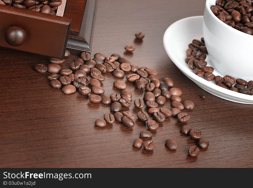 Coffee beans and old coffee mill on the table