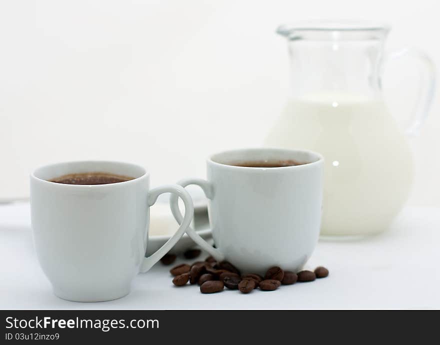 Two espresso cups with coffee over white background