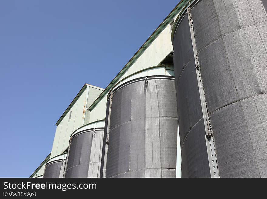 Photograph of industrial storage silo and blue sky