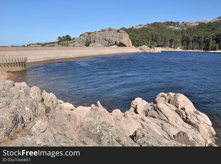 Artificial lake surrounded by a rock dam. Artificial lake surrounded by a rock dam