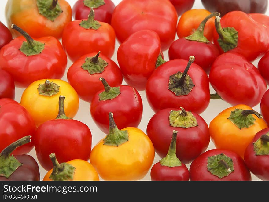 Miniature sweet peppers photographed on a white surface