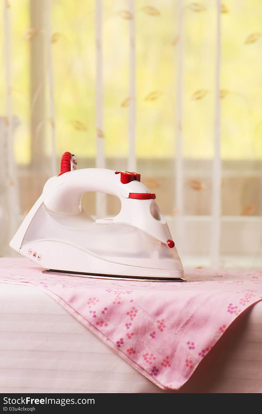 Modern electric iron on the ironing board