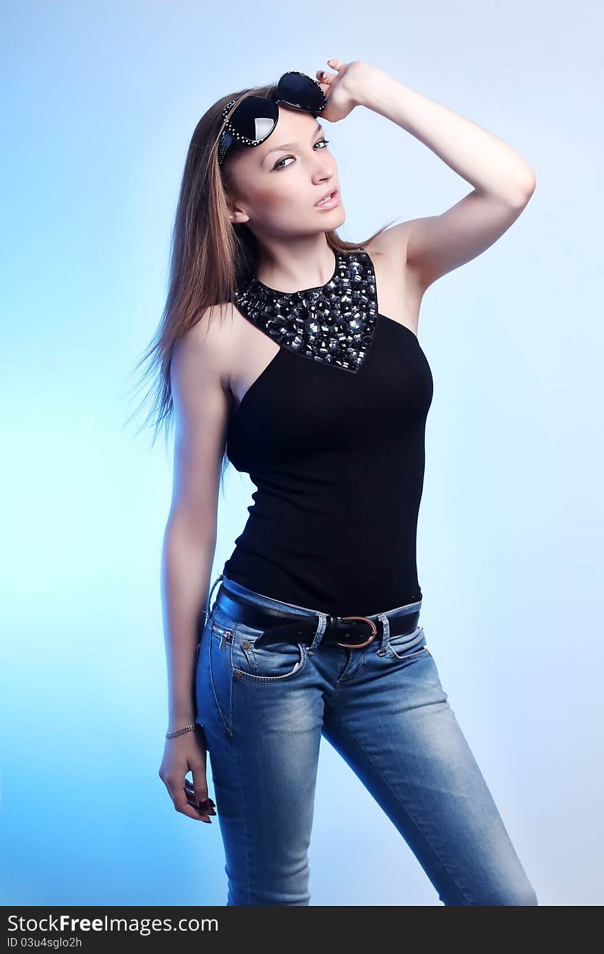 Stylish woman in jeans and dark glasses on blue background. Stylish woman in jeans and dark glasses on blue background