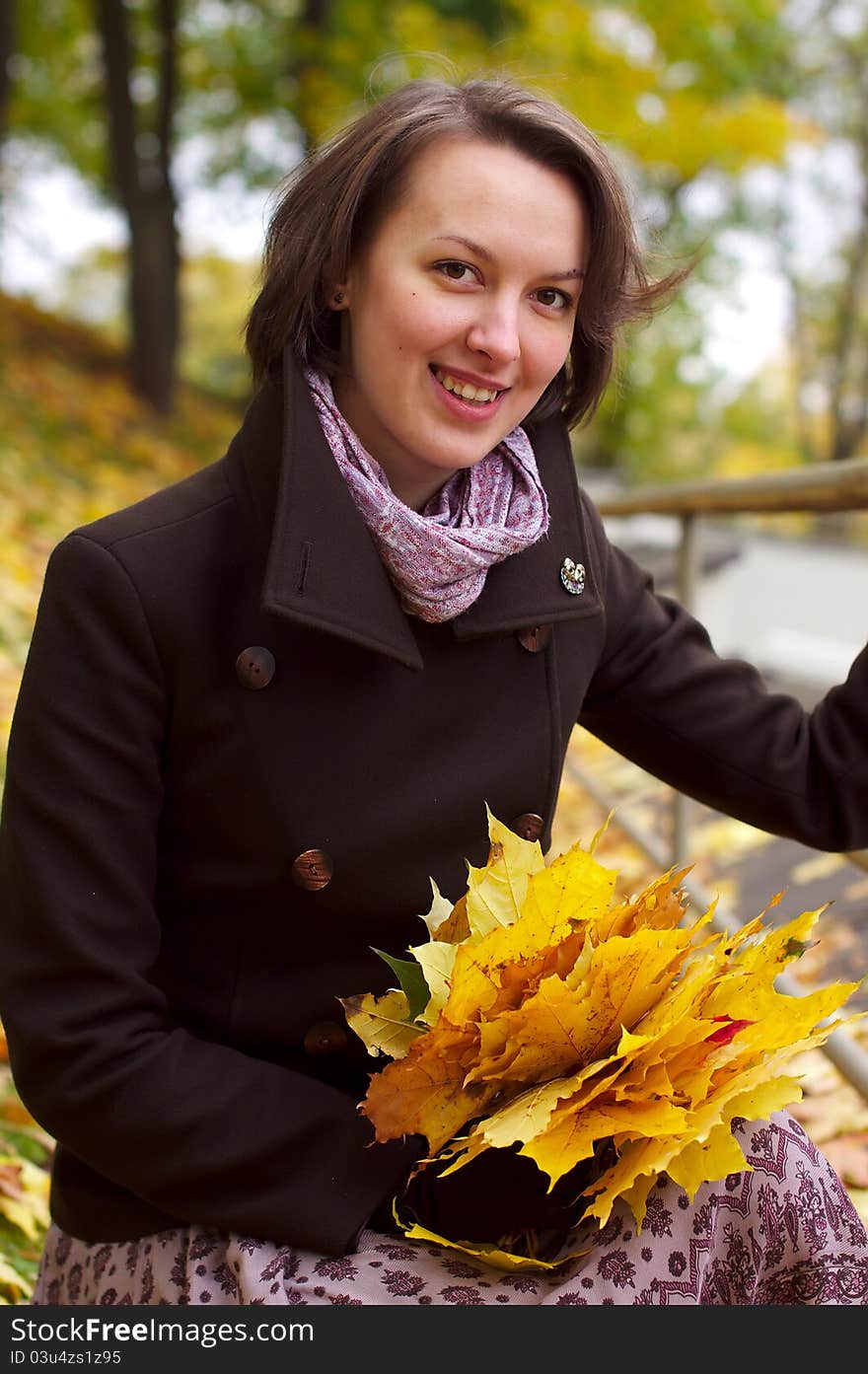 Lovely woman smiling with autumn leaves