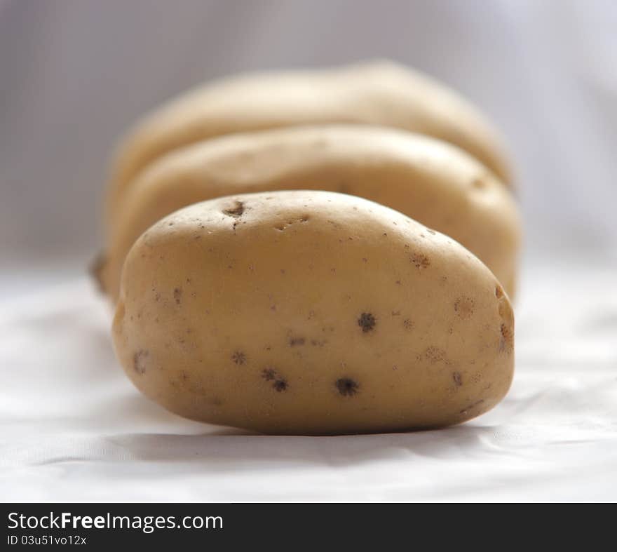 Bunch of potatoes on white background close up shoot