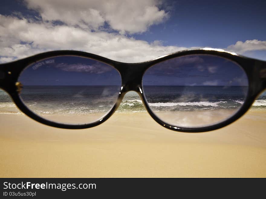 Shades in front of the camera on a bright day on a pristine Hawaiian beach. Shades in front of the camera on a bright day on a pristine Hawaiian beach.