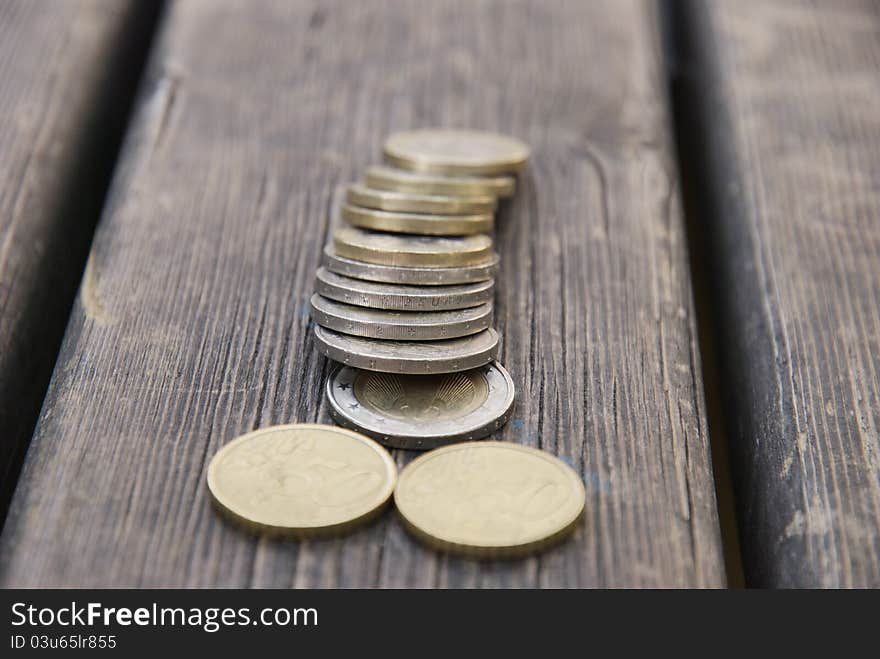 Snapshot over some euro coins on a table in a public park. Snapshot over some euro coins on a table in a public park