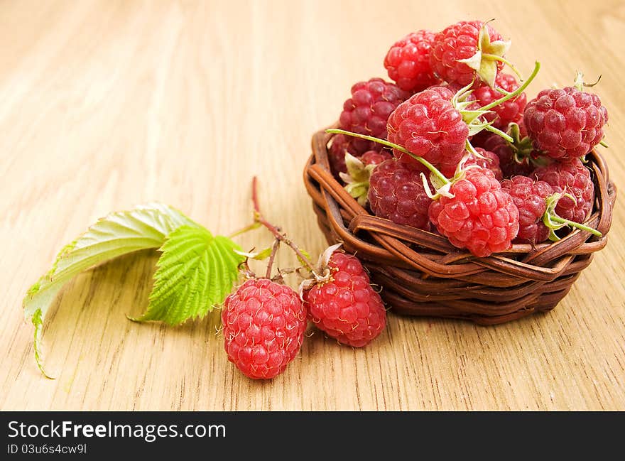 Raspberries in the basket on the table