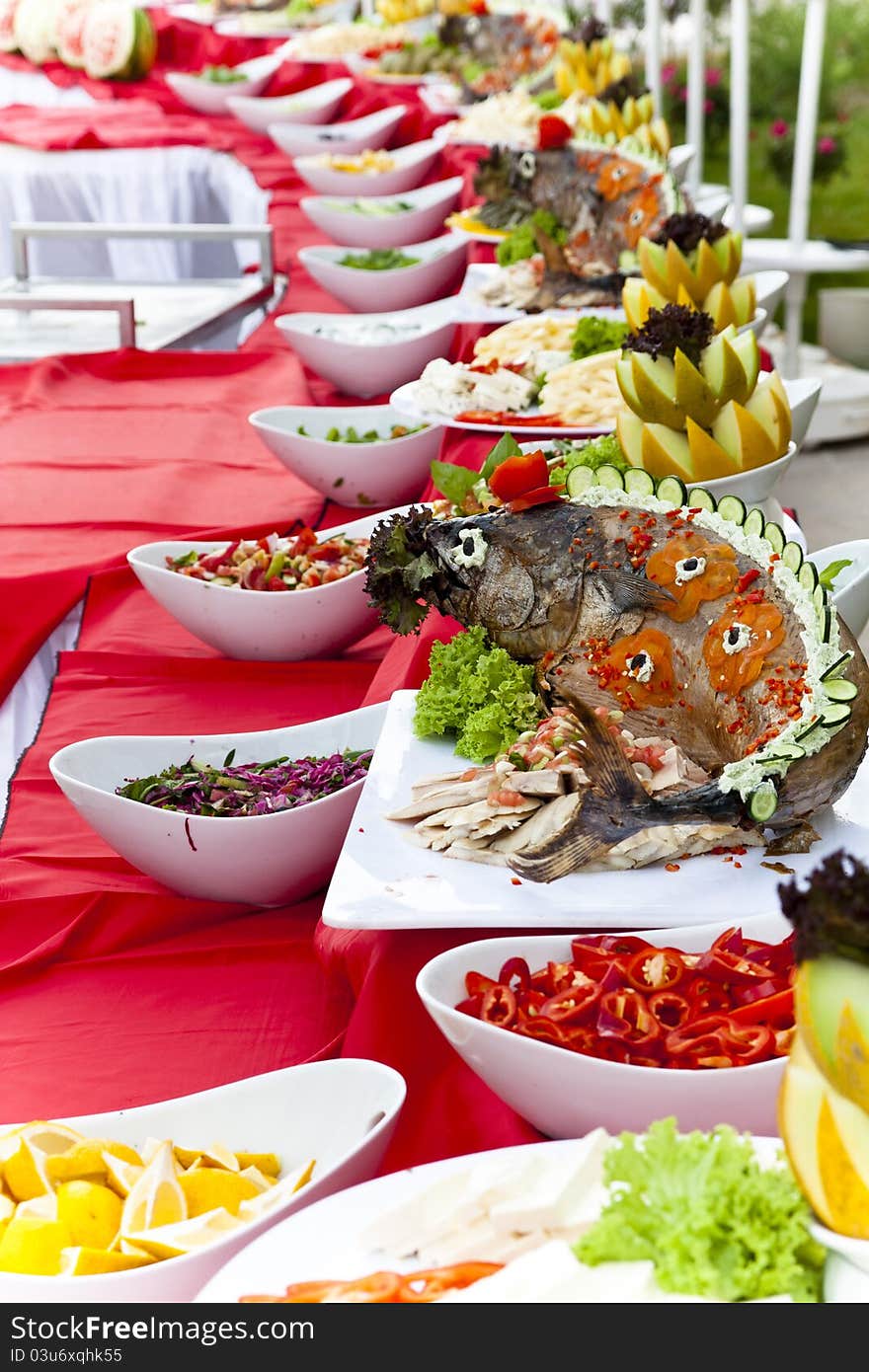 Celebratory food: whole stuffed fried  tuna fish on served table  with tomatoes lemon and pepper. Celebratory food: whole stuffed fried  tuna fish on served table  with tomatoes lemon and pepper