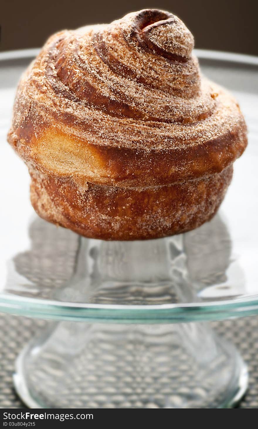 Baked cinnamon bun on glass display plate. Baked cinnamon bun on glass display plate