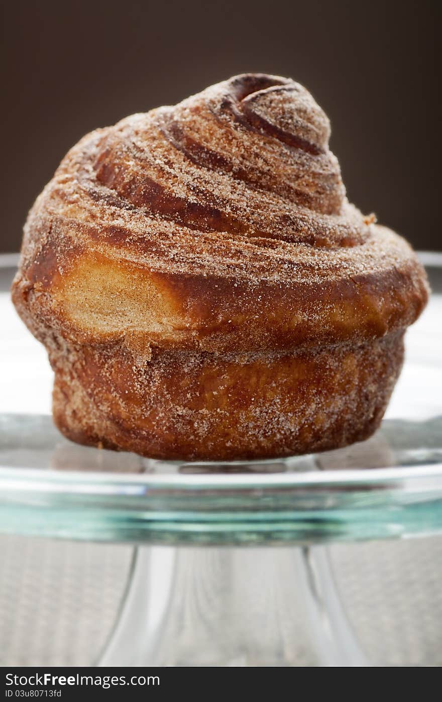 Baked cinnamon bun on glass display plate. Baked cinnamon bun on glass display plate