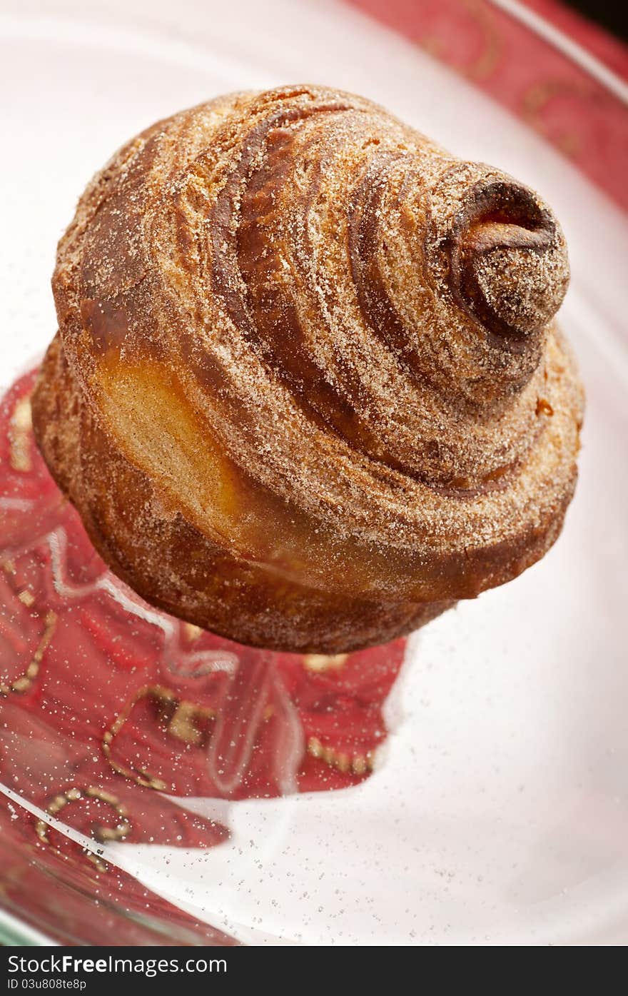 Baked cinnamon bun on glass display plate. Baked cinnamon bun on glass display plate