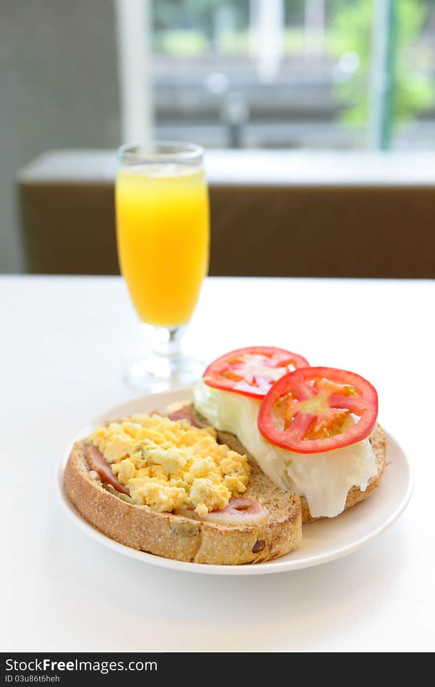 Delicious breakfast include egg, tomato , toast and orange juice, good for health with window. Delicious breakfast include egg, tomato , toast and orange juice, good for health with window