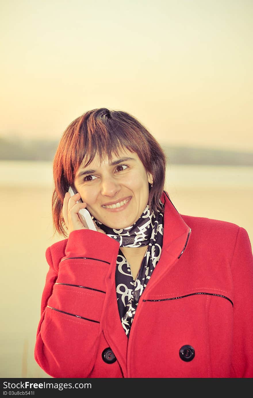 Beautiful  young woman talking on telephone outdoors. Beautiful  young woman talking on telephone outdoors