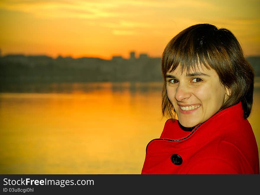 Beautiful young woman near the lake at sunset. Beautiful young woman near the lake at sunset