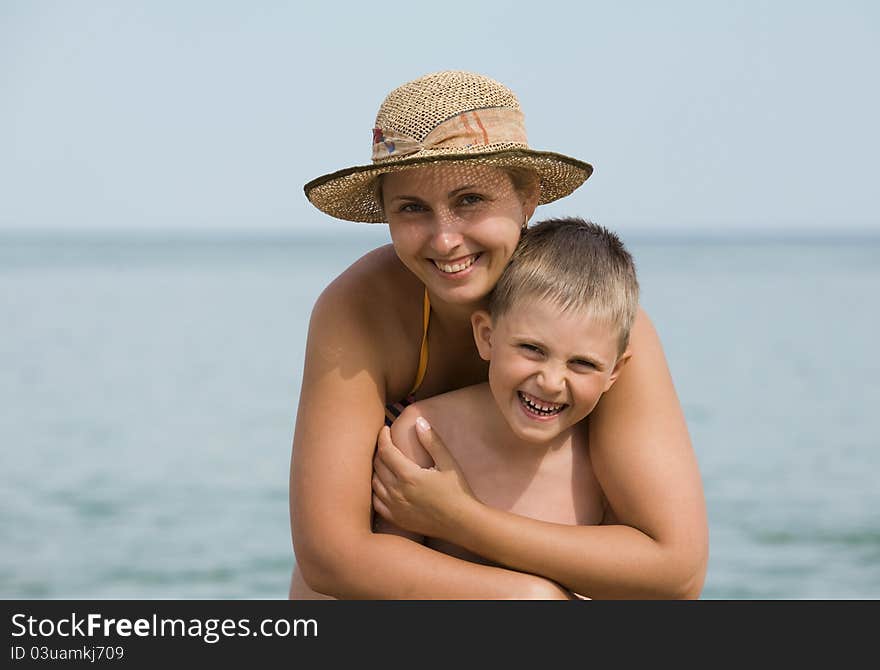 Mother with the son smile against the sea