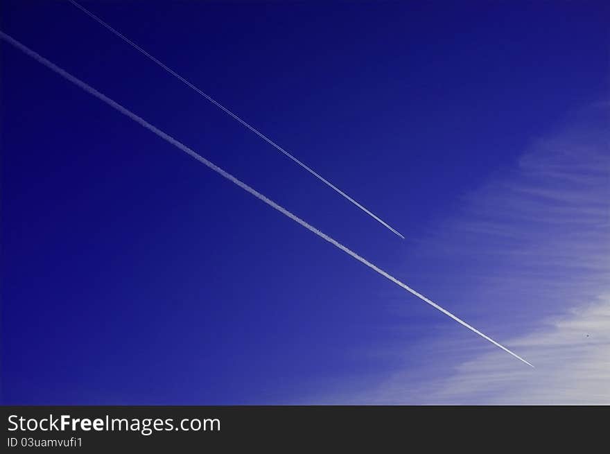 Two jet airplanes racing in the blue sky. Two jet airplanes racing in the blue sky