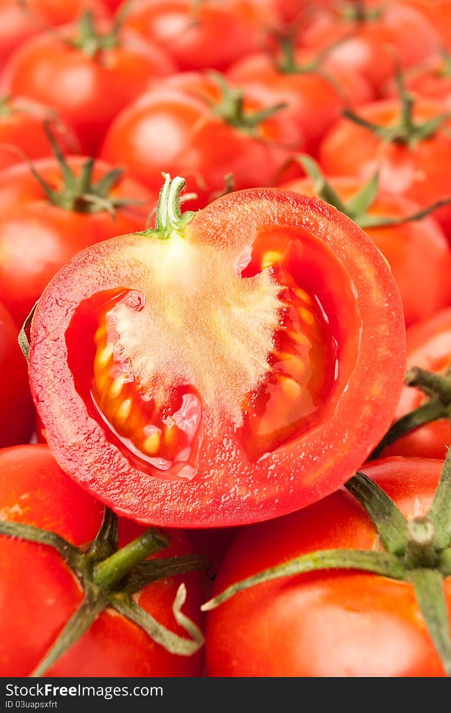 Single cut tomato on top of blurred tomato rows. Single cut tomato on top of blurred tomato rows