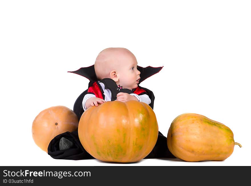 Little baby boy sitting in black halloween cloak near pumpkins. Little baby boy sitting in black halloween cloak near pumpkins