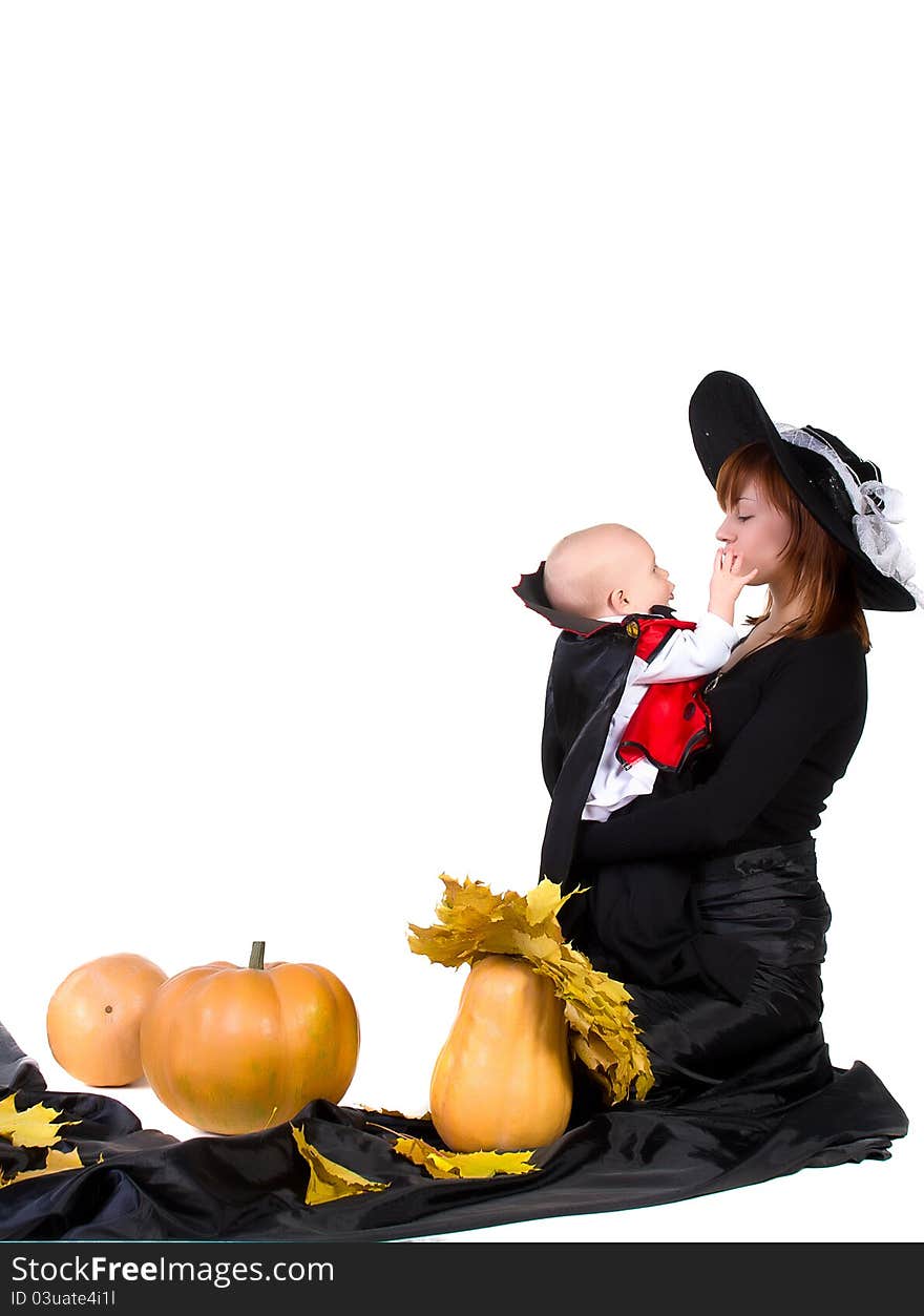 Halloween baby with mother near pumpking