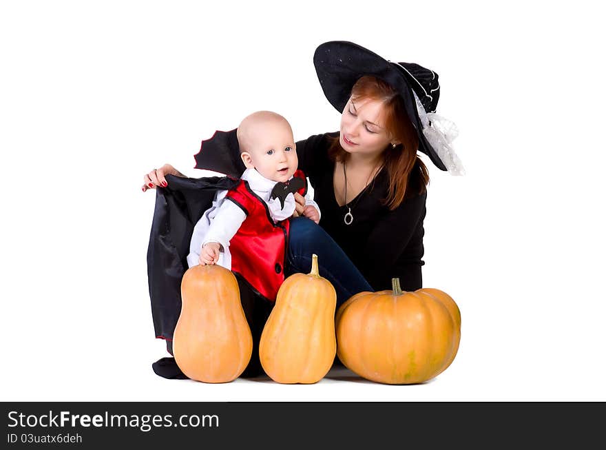 Halloween baby boy with mother witch near pumpking