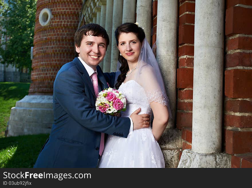 Happy bride and groom with bouquet in wedding walk