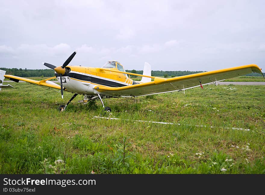 Light aircraft parked on the background of a cloudy sky