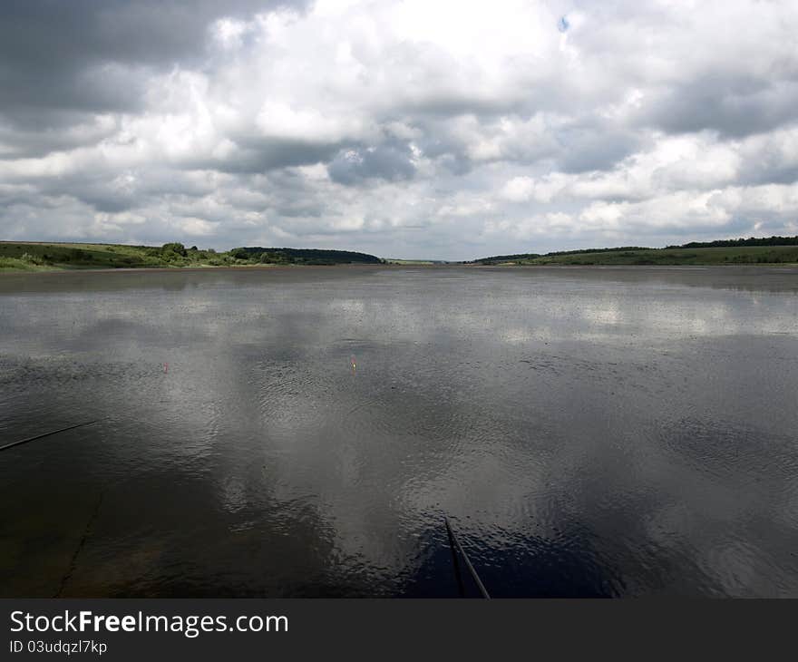 Low heavy clouds over lake. forest in the background. Low heavy clouds over lake. forest in the background