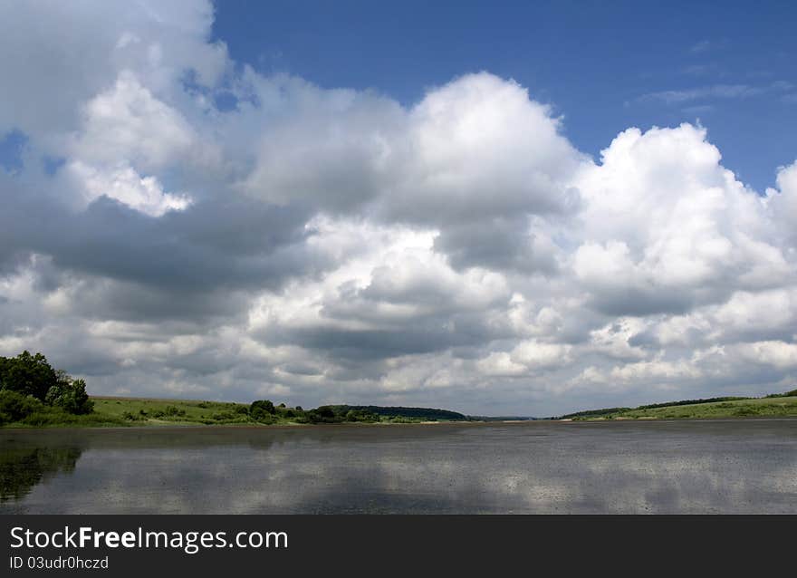 Low heavy clouds over lake. forest in the background. Low heavy clouds over lake. forest in the background