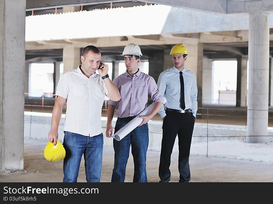 Team of business people in group, architect and engeneer on construciton site check documents and business workflow on new building. Team of business people in group, architect and engeneer on construciton site check documents and business workflow on new building