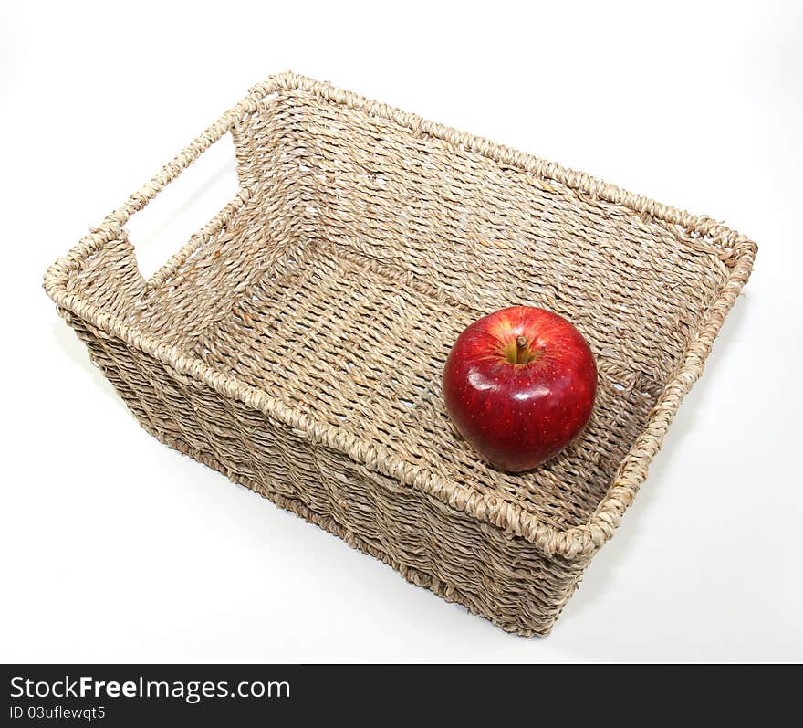 One Gala apples in a woven seagrass basket. Isolated on a white background. One Gala apples in a woven seagrass basket. Isolated on a white background.