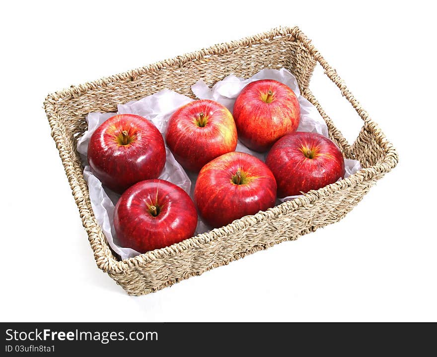 Six Gala apples in a woven seagrass basket. Isolated on a white background. Six Gala apples in a woven seagrass basket. Isolated on a white background.