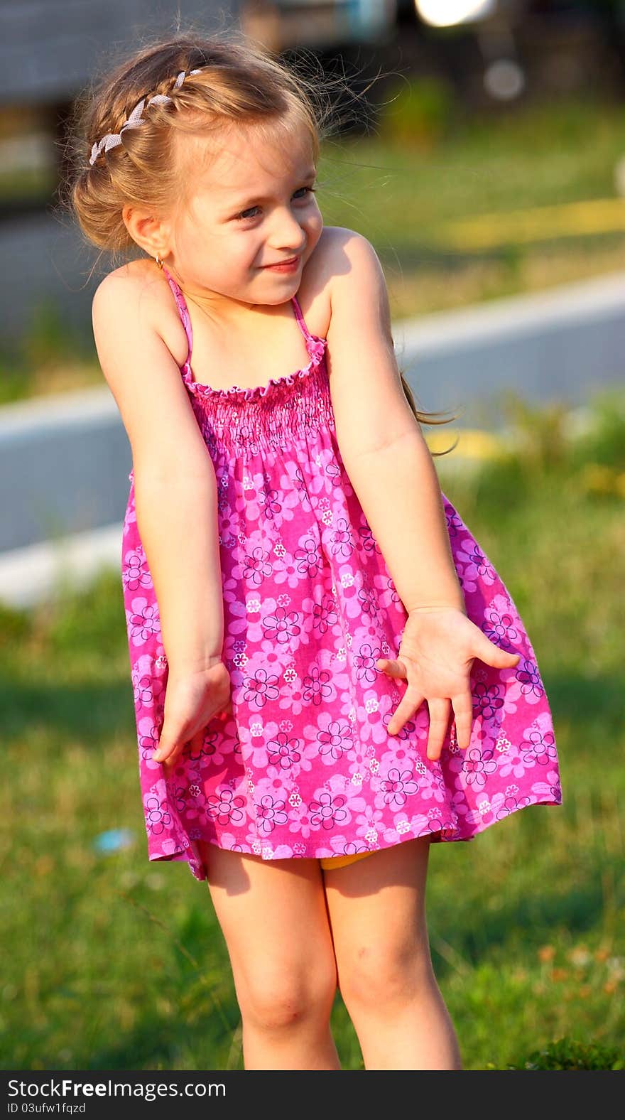 A beautiful girl making gesture I don`t know with her arms (hands),outdoor.