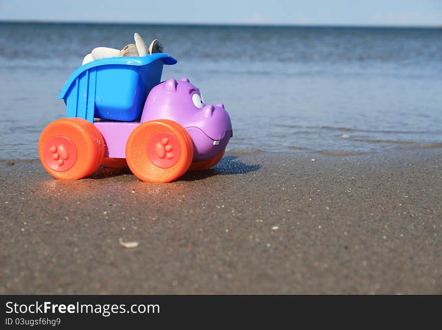 The toy truck on the canada beach, truck is loaded with a shell. The toy truck on the canada beach, truck is loaded with a shell.