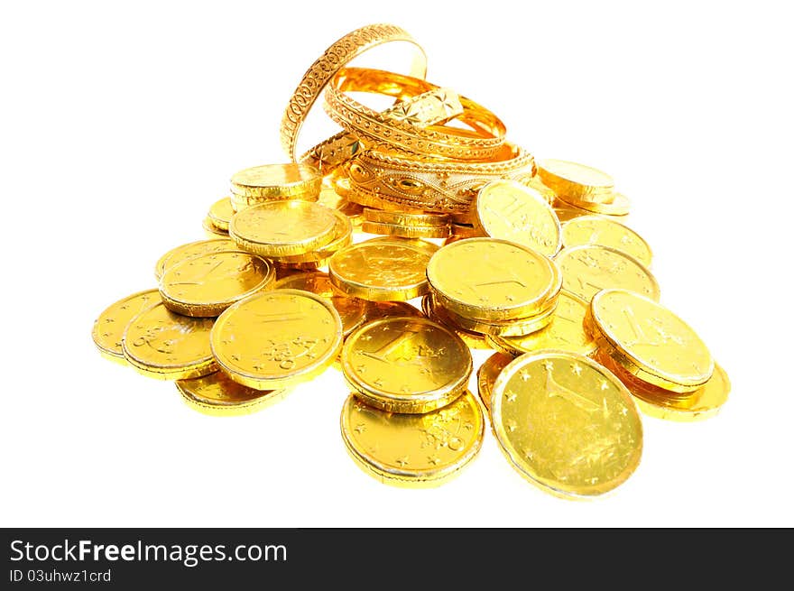 Gold coins and bracelets on a white background, whide lens shot. Gold coins and bracelets on a white background, whide lens shot