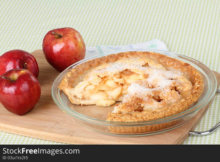 Sliced apple pie and apples on a tray