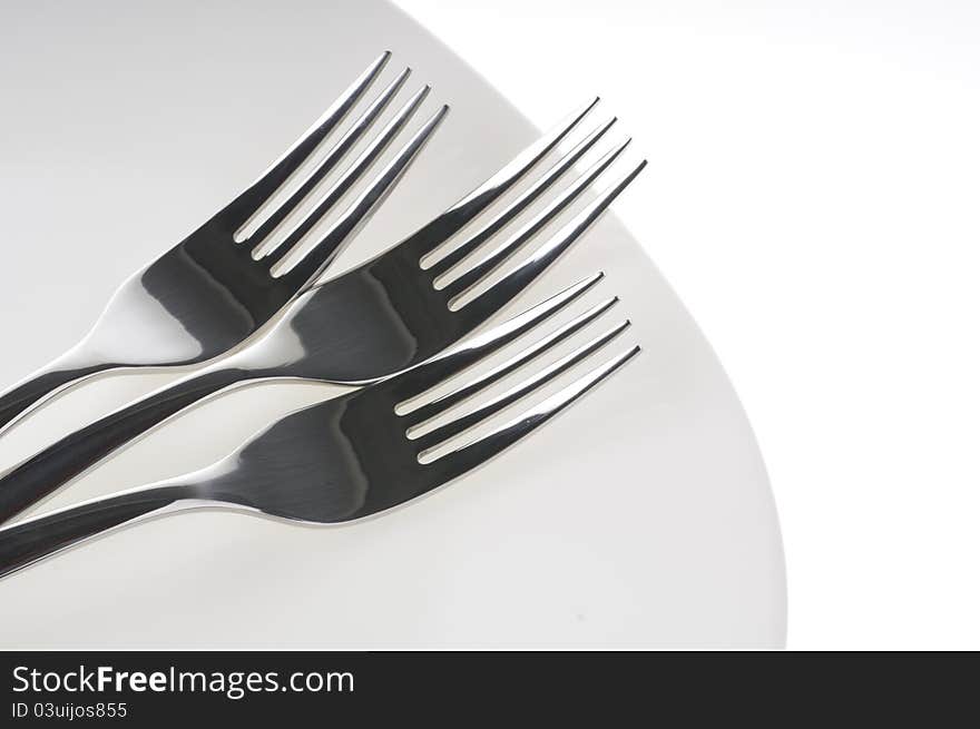 Forks on a plate isolated over white background. Forks on a plate isolated over white background